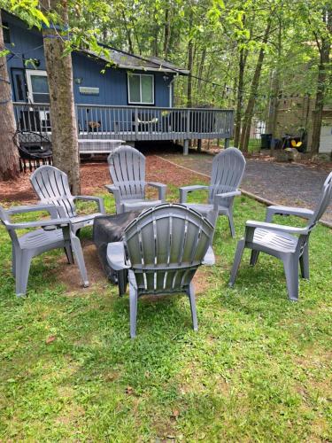 a group of chairs sitting in the grass at Fun Home in Pocono with Gameroom-Firpit-BBQ Grill-TV and AC in all rooms in Tobyhanna