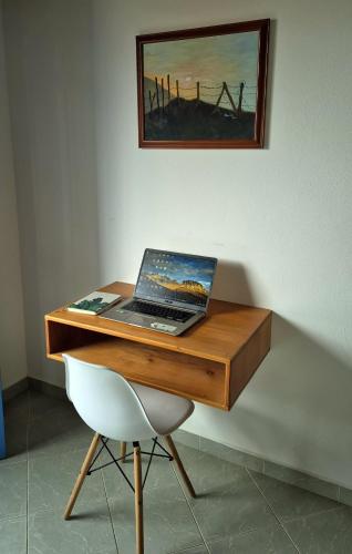 a laptop computer sitting on top of a wooden desk at aparta hotel La Gruta Jericó, apartamento con balcón in Jericó
