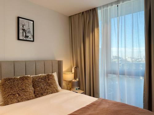 a bedroom with a bed and a large window at Valentine Sweet Monlando 3 queens private spa pool gym sauna and parking Sleeps 6 in Melbourne