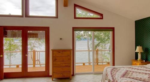 a bedroom with a bed and sliding glass doors at Waterfront Hood Canal-Private Beach-Boat-Kayaks in Brinnon