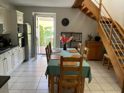 une cuisine et une salle à manger avec une table et des chaises dans l'établissement Gîte de caractère au cœur des vignes avec jardin, vélos et équipements bébé - FR-1-306-796, à Châteauthébaud