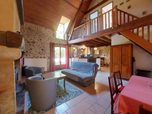 - un salon avec un escalier, une table et des chaises dans l'établissement Gîte chaleureux dans un ancien corps de ferme avec wifi, cheminée et grand jardin à Châteaudun - FR-1-581-71, à Châteaudun