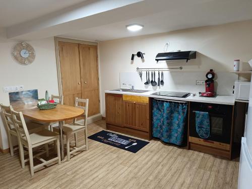 une cuisine avec une table en bois, une table et un ordinateur de table dans l'établissement Gîte 3 chambres, jardin, proche Baccarat et Lacs de Pierre-Percée, animaux acceptés - FR-1-584-36, à Harbouey