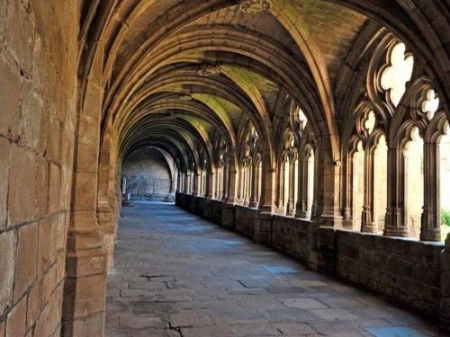 an arcade of a building with arches and windows at Gîte chaleureux entre festivals, nature et confort avec wifi à Jullianges - FR-1-582-237 in Jullianges