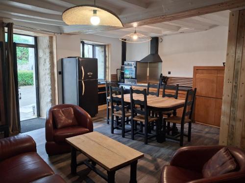 une cuisine avec une table, des chaises et un réfrigérateur dans l'établissement Maison de charme près de la forêt de la Charnie, 8 pers. - FR-1-410-469, à Chemiré-en-Charnie