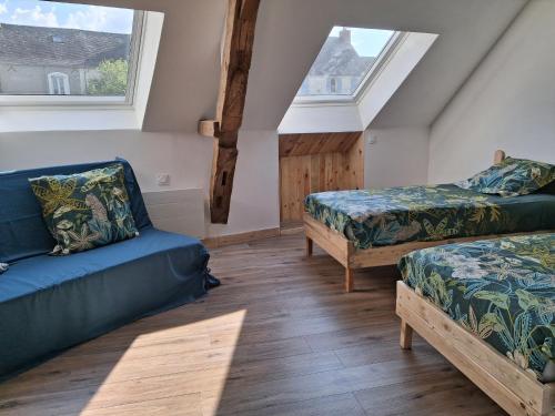 Cette chambre comprend deux lits, un canapé et des fenêtres. dans l'établissement Maison de charme près de la forêt de la Charnie, 8 pers. - FR-1-410-469, à Chemiré-en-Charnie