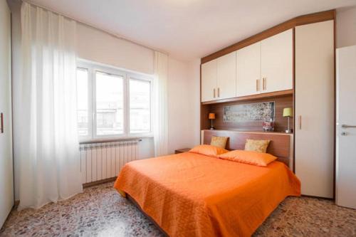 a bedroom with an orange bed and a window at Tempio del Sole in Rome