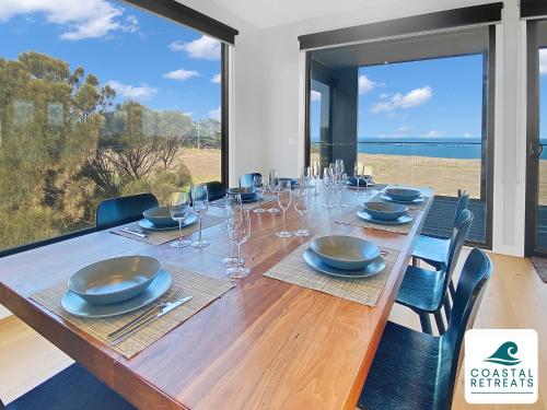a long wooden table with chairs and a large window at Alonda - Ocean Views in San Remo