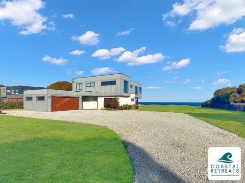 a house on a gravel road in front of the ocean at Alonda - Ocean Views in San Remo