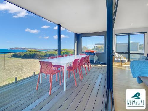 a dining room with a table and chairs on a deck at Alonda - Ocean Views in San Remo