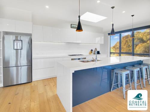 a kitchen with white and blue counters and a refrigerator at Alonda - Ocean Views in San Remo