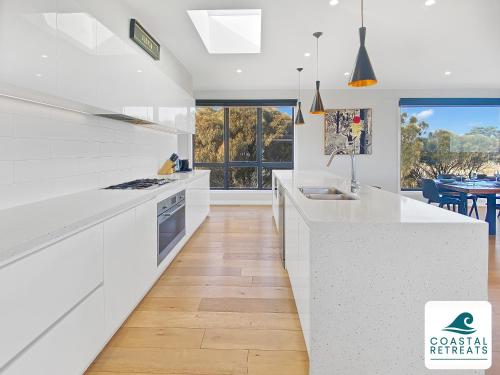 a kitchen with white counters and a large window at Alonda - Ocean Views in San Remo