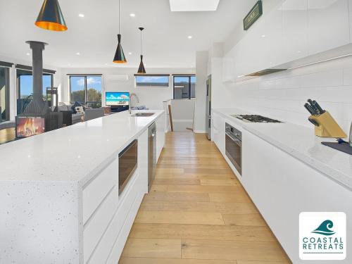 a kitchen with white countertops and a living room at Alonda - Ocean Views in San Remo