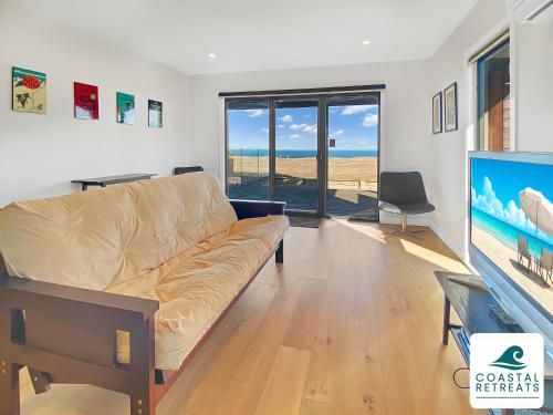 a living room with a couch and a flat screen tv at Alonda - Ocean Views in San Remo