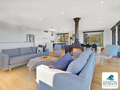 a living room with blue couches and a fireplace at Alonda - Ocean Views in San Remo