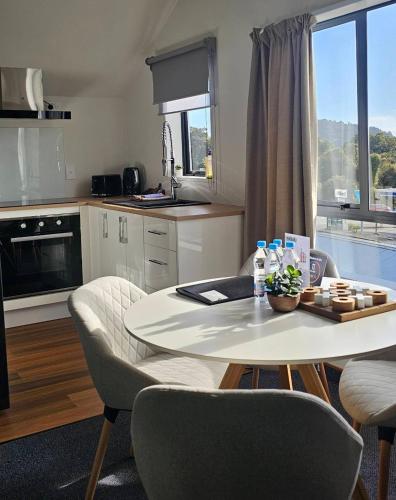 a kitchen with a table and chairs and a kitchen with a window at Wild Kea Lodge Franz Josef in Franz Josef