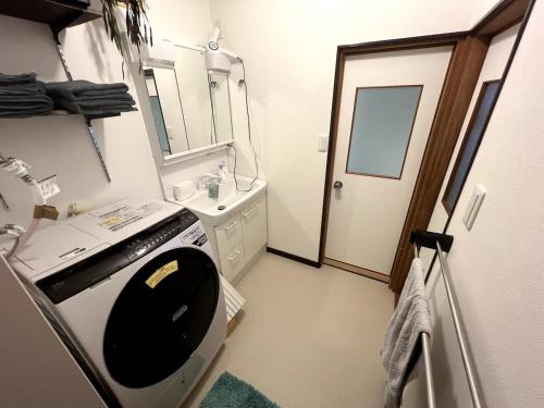 a bathroom with a stove and a sink and a mirror at MiLiS 自分を取り戻す湖畔の時間 in Ōsaki