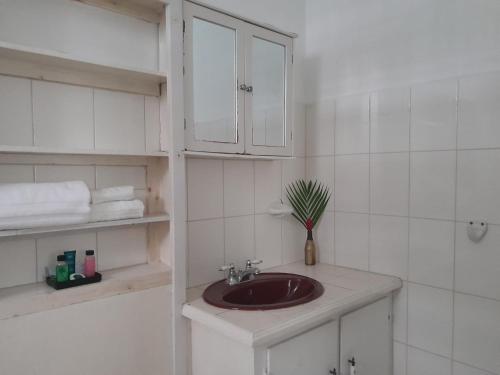 a bathroom with a sink and white cabinets at Villa Copthall in Trafalgar