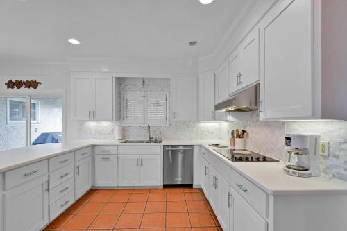 a white kitchen with white cabinets and an orange tile floor at 4310 Ninth Street in Saint Simons Island
