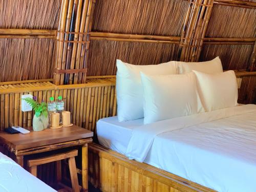 a bedroom with two beds and a table with a night stand at Woodstock Jungle Camp in Cat Ba