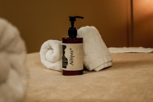 a bottle of moisturizing shampoo and a towel at Boutique Hotel Caramel in Syvota