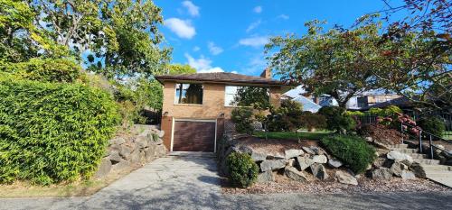 a brick house with a garage and a stone wall at HomeSmart: Cozy Charm Meets High-Tech in Prime Area in Seattle