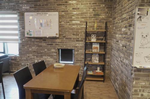 a dining room with a table and a brick wall at Hotel Iam in Suncheon