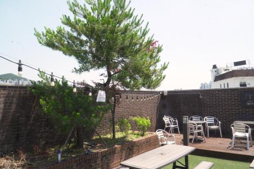 a patio with a table and chairs and a tree at Hotel Iam in Suncheon