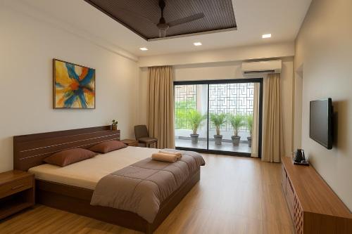 a bedroom with a large bed and a large window at Skywood Villa Apartment in Lucknow
