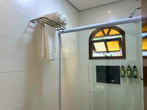 a bathroom with a glass shower with a window at Porto Marina Resort in Ilha Comprida