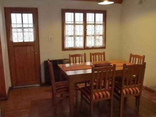 a dining room with a wooden table and chairs at Cabaña Albar in San Martín de los Andes