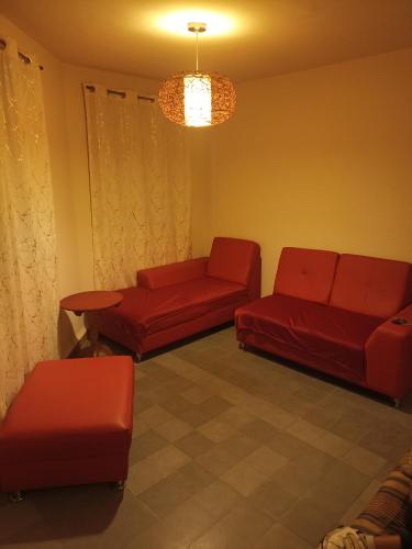 a living room with red furniture and a chandelier at Amplio, cómodo y tranquilo a 10 min del aeropuerto, basilica y centro in Mexico City