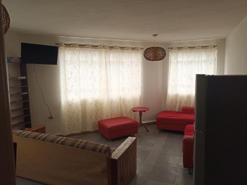 a living room with a couch and a red chair at Amplio, cómodo y tranquilo a 10 min del aeropuerto, basilica y centro in Mexico City