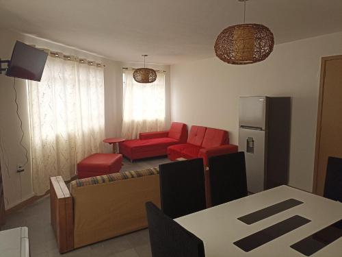 a living room with a couch and red chairs at Amplio, cómodo y tranquilo a 10 min del aeropuerto, basilica y centro in Mexico City