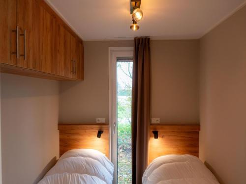 two beds in a bedroom with a window at Luxury holiday home surrounded by water in Sint Nicolaasga