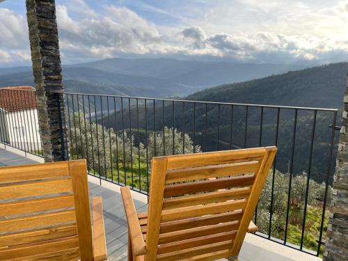 two wooden chairs sitting on a balcony with a view at Serradinho Country House 