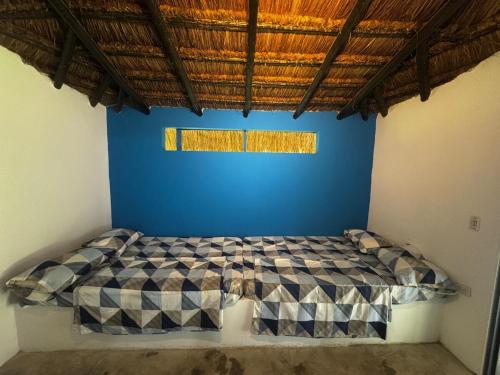 a bedroom with a bed in a blue wall at Casa El Cielo in Piedecuesta