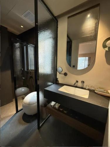 a bathroom with a sink and a mirror at Chaozhou Meisu Ancient City Store in Chaozhou