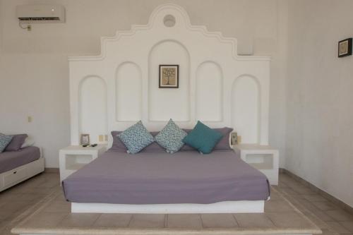 une chambre avec un grand lit avec des oreillers bleus dans l'établissement Apt with Jacuzzi Ixtapa Zihuatanejo 3 BR, à Ixtapa