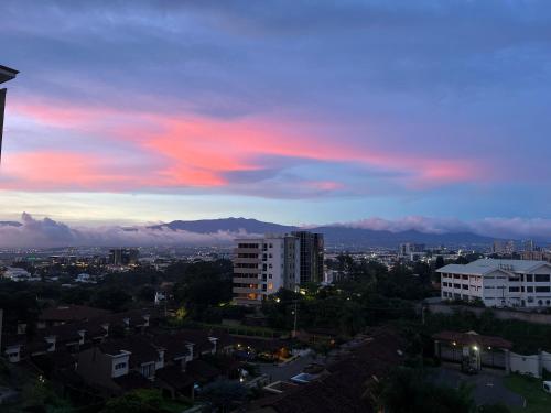 a view of a city with a pink sky at Nice and confortable 2 bedrooms apartment in Escazu in San Antonio