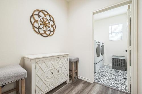 a white kitchen with a counter and a refrigerator at Hi-Tech Haven by Hospital & Lake in Granbury