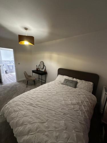 タプロウにあるModern Private Room and Bath in Maidenhead Near Heathrow Airportのベッドとテーブルと椅子のある寝室