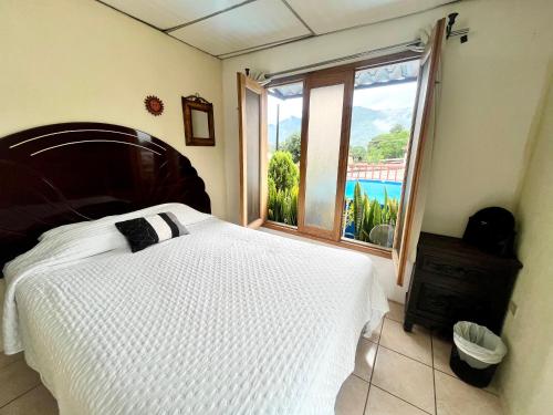 a bedroom with a large bed and a window at Jireh guesthouse in Antigua Guatemala