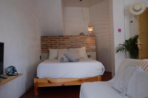 a bed in a room with a brick wall at Casa Roma in Taxco de Alarcón