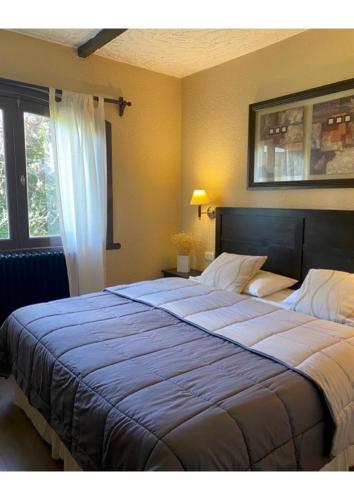 a bedroom with a large bed with a blue blanket at Del Prado in San Carlos de Bariloche