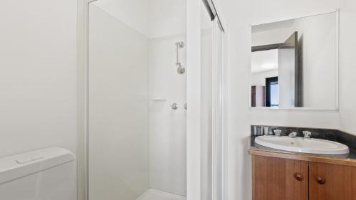 a white bathroom with a sink and a mirror at Alpine Heights 18 in Mount Hotham