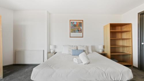 a bedroom with a large white bed with two pillows at Alpine Heights 18 in Mount Hotham