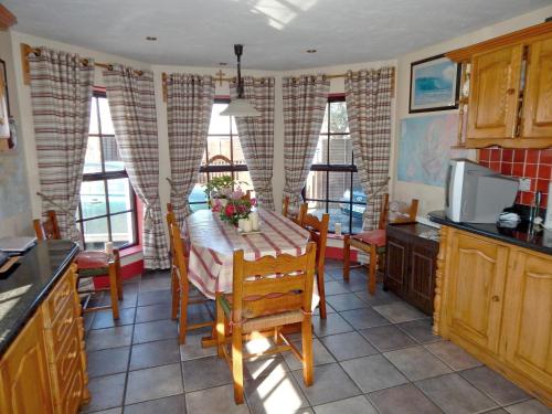 a kitchen with a table with flowers on it at Barkers Accommodation in Spanish Point
