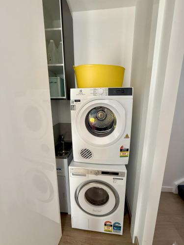 a washer and dryer in a small room at 5min Walk to Lift 3BR Luxe Chalet with Views & Fire in Mount Buller