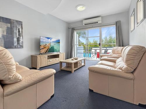 a living room with two couches and a tv at 3-Bed with Alfresco Dining & Pool in Batemans Bay in Batemans Bay